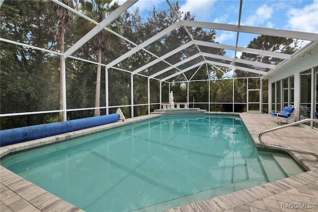 view of swimming pool with glass enclosure and a patio area