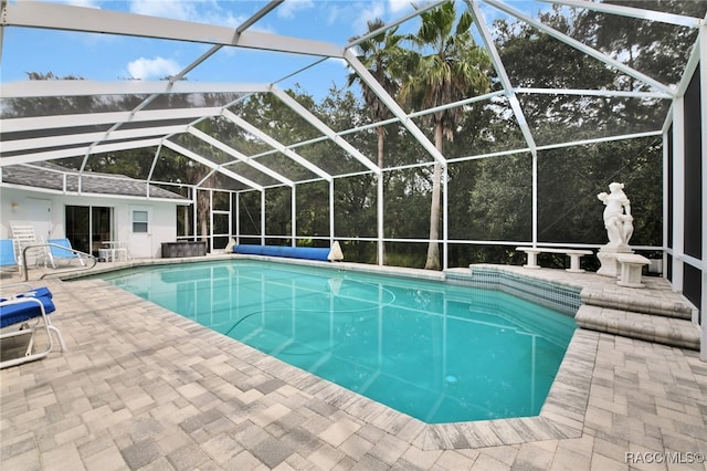 view of swimming pool with a patio area and a lanai