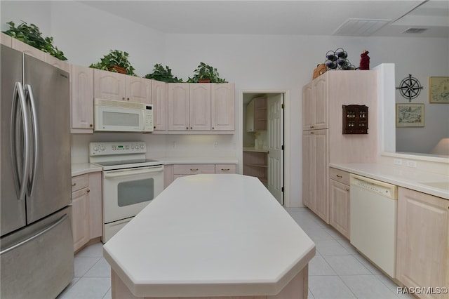 kitchen featuring a kitchen island, white appliances, and light tile patterned floors