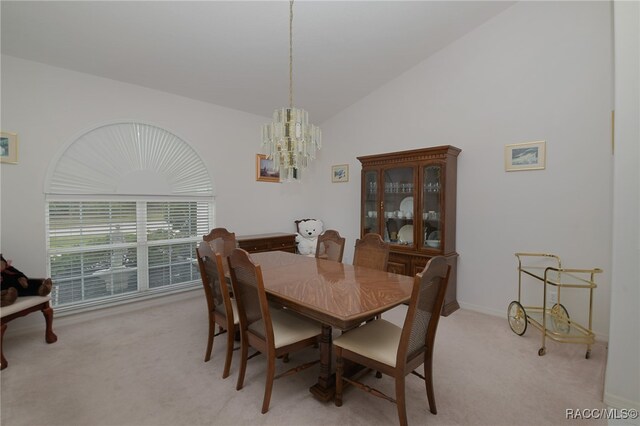 carpeted dining area featuring a notable chandelier and vaulted ceiling