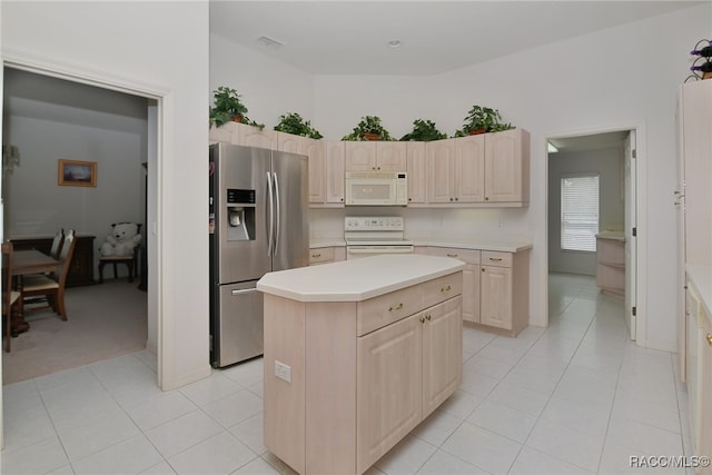 kitchen featuring light tile patterned floors, white appliances, a kitchen island, and light brown cabinets