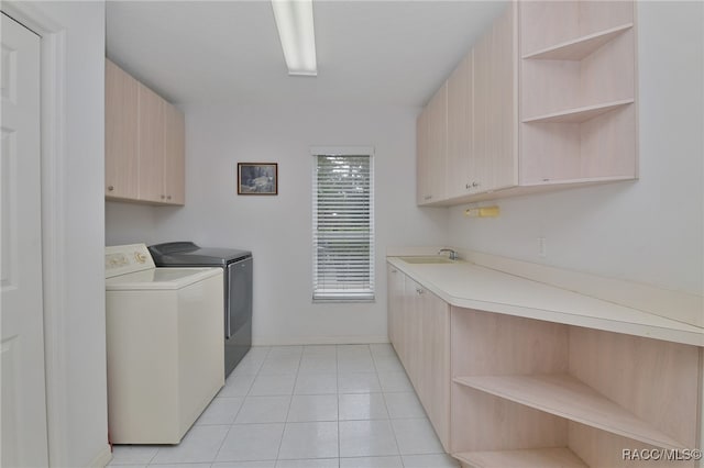 laundry area with light tile patterned flooring, cabinets, independent washer and dryer, and sink