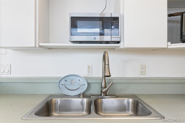 interior details featuring white cabinets and sink