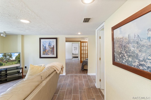 hallway featuring a textured ceiling and french doors