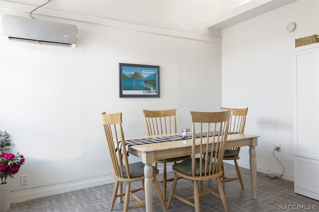 dining room featuring a wall unit AC and parquet floors