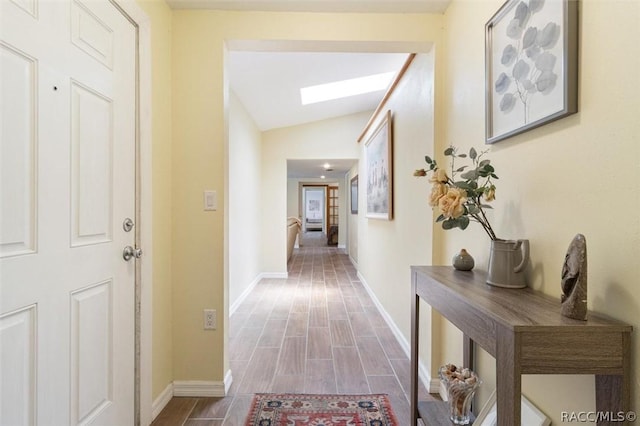 corridor with lofted ceiling with skylight