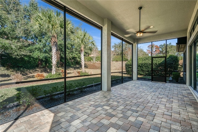 unfurnished sunroom featuring ceiling fan