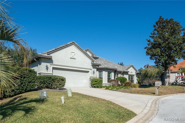 view of front of home with a front yard and a garage