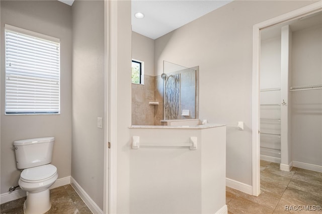 bathroom featuring toilet and a tile shower