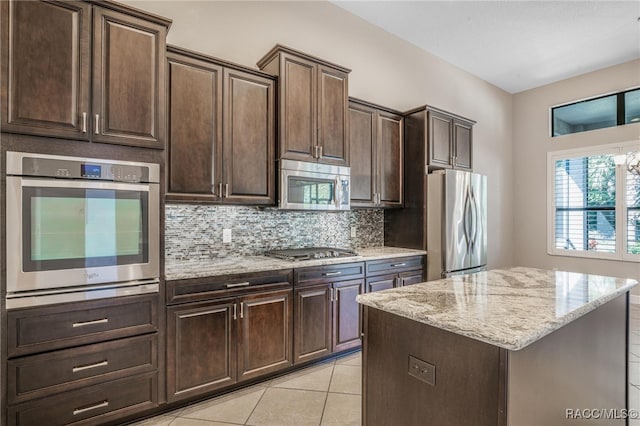 kitchen with a kitchen island, appliances with stainless steel finishes, and dark brown cabinetry