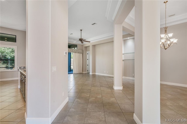 hall with light tile patterned flooring, ornamental molding, and a healthy amount of sunlight