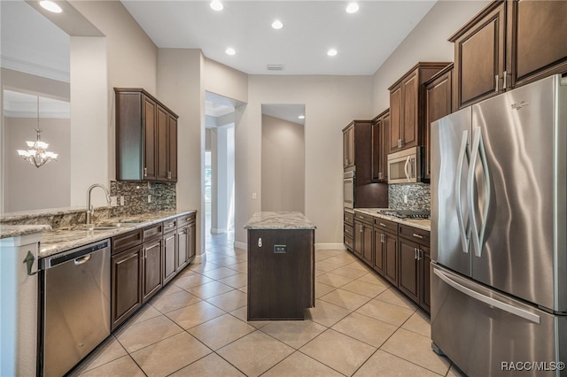 kitchen with a center island, appliances with stainless steel finishes, decorative backsplash, and sink