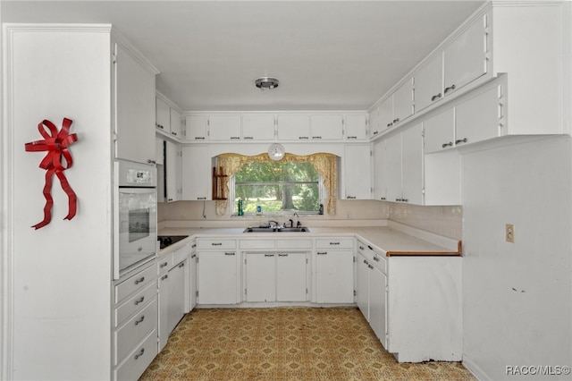 kitchen with white cabinetry, sink, tasteful backsplash, oven, and black electric cooktop