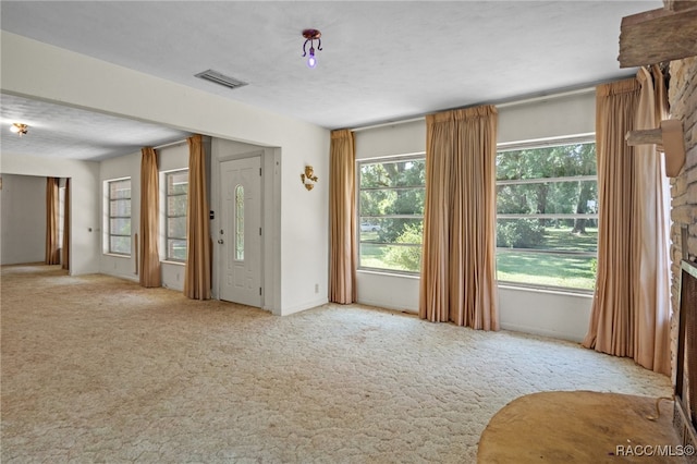 empty room featuring light colored carpet and a textured ceiling