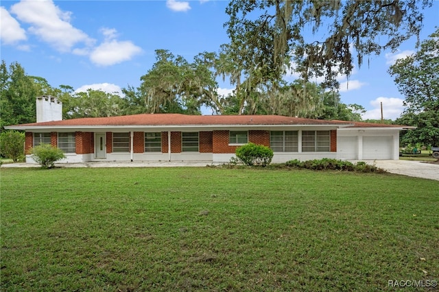 ranch-style house with covered porch, a garage, and a front yard