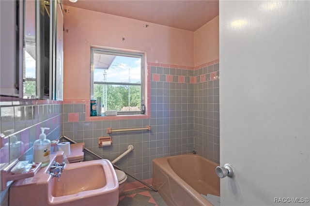 bathroom featuring tile walls and sink