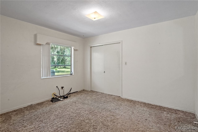 carpeted spare room with a textured ceiling