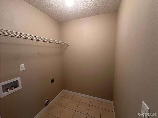 laundry room featuring electric dryer hookup, hookup for a washing machine, a textured ceiling, light tile patterned floors, and baseboards