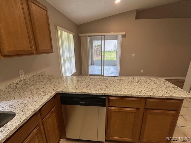 kitchen featuring dishwasher, lofted ceiling, a peninsula, light tile patterned floors, and light stone counters