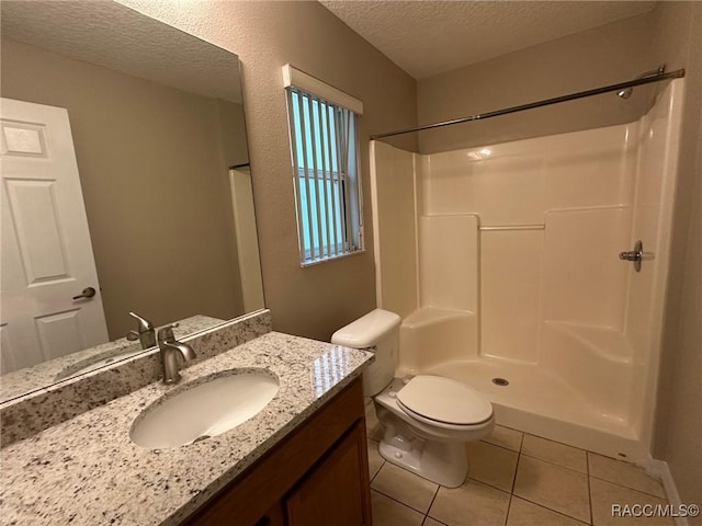 full bathroom with a textured ceiling, tile patterned floors, a shower, toilet, and vanity