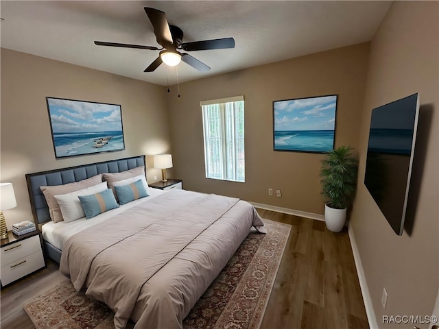 bedroom with wood finished floors, baseboards, and ceiling fan