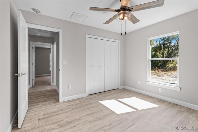 unfurnished bedroom with ceiling fan, visible vents, baseboards, a closet, and light wood-type flooring