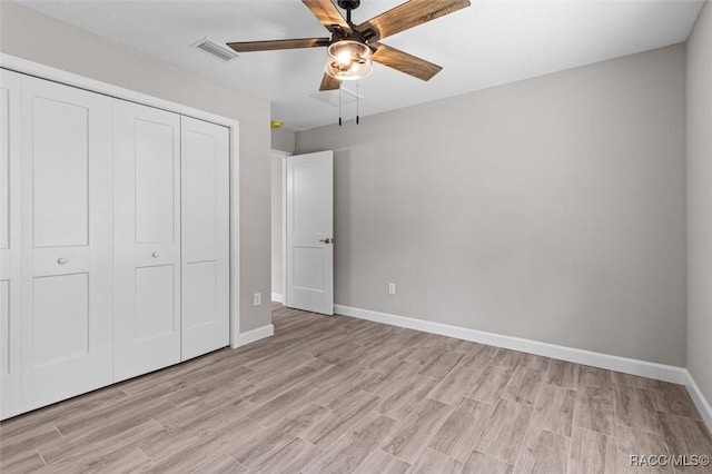 unfurnished bedroom with light wood-style floors, baseboards, visible vents, and a closet