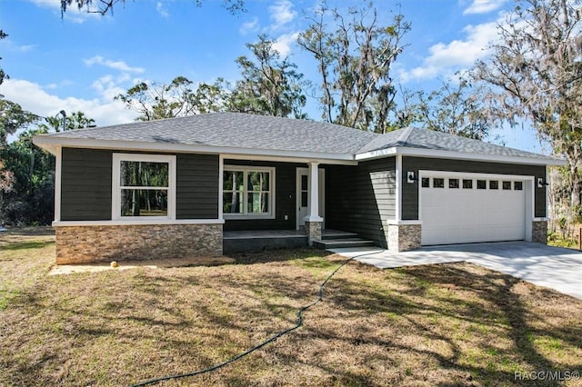 view of front of property featuring a garage, stone siding, driveway, and a front lawn