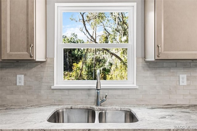 kitchen with backsplash, a sink, and a healthy amount of sunlight