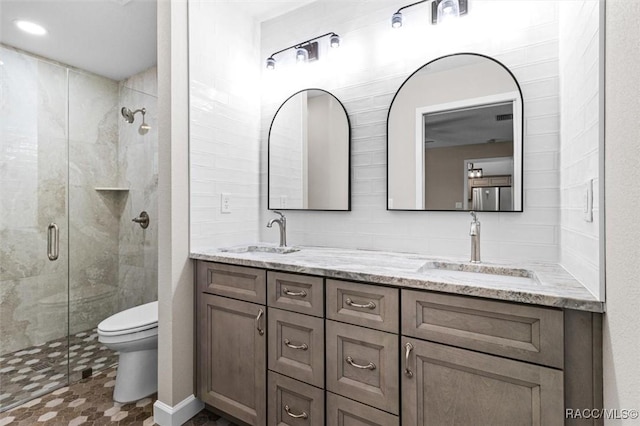 bathroom with a stall shower, a sink, and toilet