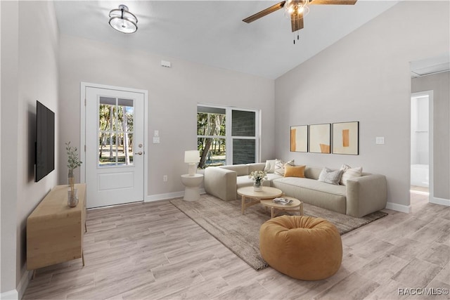 living room with high vaulted ceiling, light wood-style flooring, baseboards, and a ceiling fan