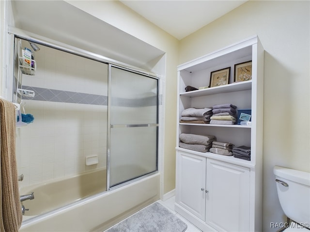 bathroom with tile patterned flooring, toilet, and enclosed tub / shower combo