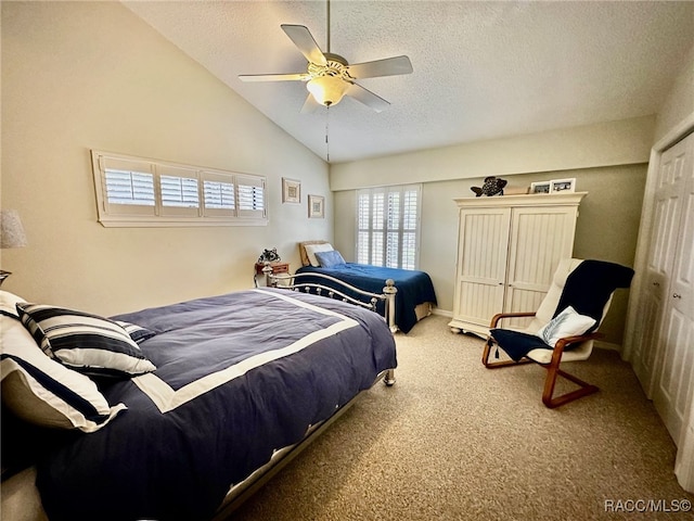 bedroom featuring carpet, high vaulted ceiling, ceiling fan, a textured ceiling, and a closet