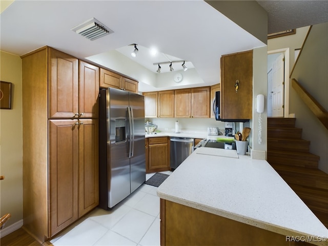 kitchen with light tile patterned floors, stainless steel appliances, and track lighting