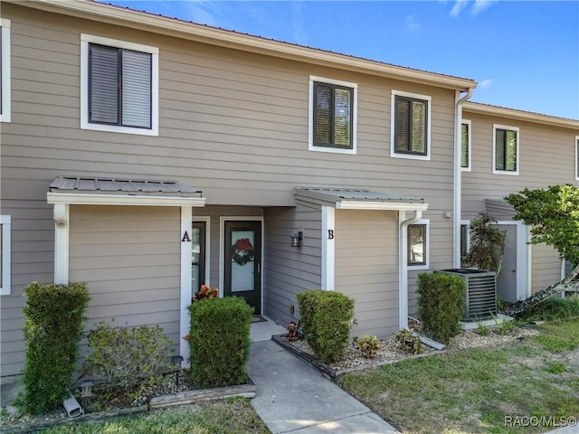 townhome / multi-family property featuring central air condition unit and metal roof