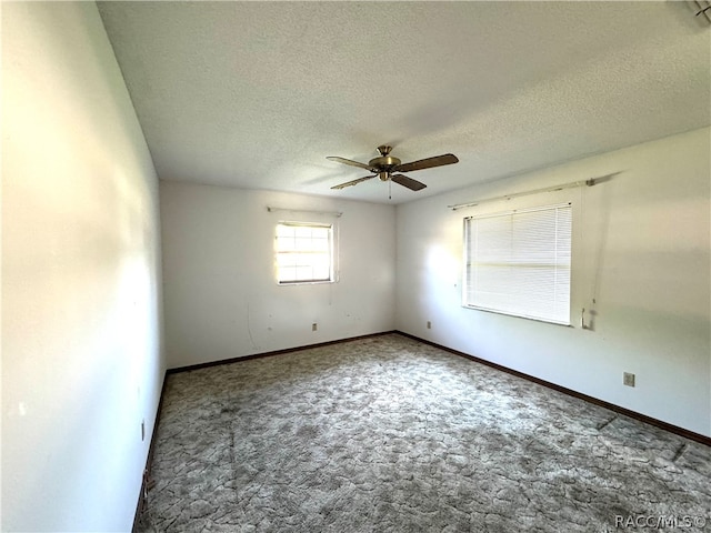 carpeted empty room featuring ceiling fan and a textured ceiling