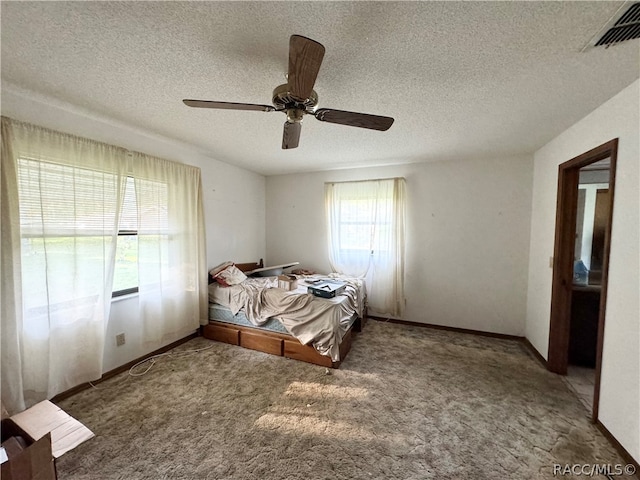 unfurnished bedroom with carpet flooring, ceiling fan, and a textured ceiling