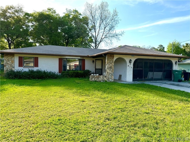 ranch-style house featuring a garage and a front lawn