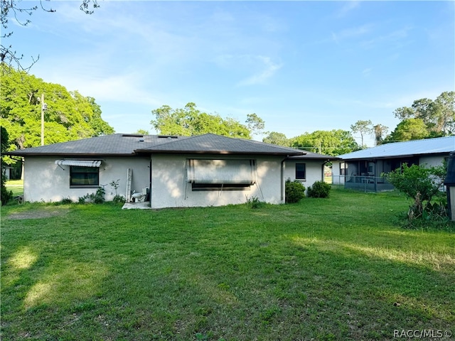 back of property featuring a lawn