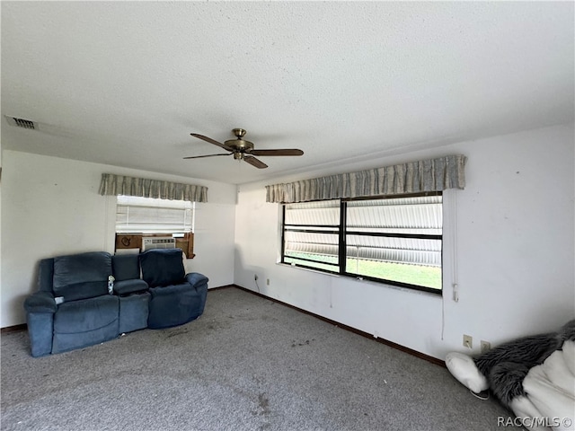 carpeted living room with ceiling fan, cooling unit, and a textured ceiling