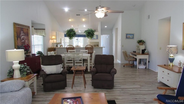living room with high vaulted ceiling, a ceiling fan, light wood-style flooring, and visible vents