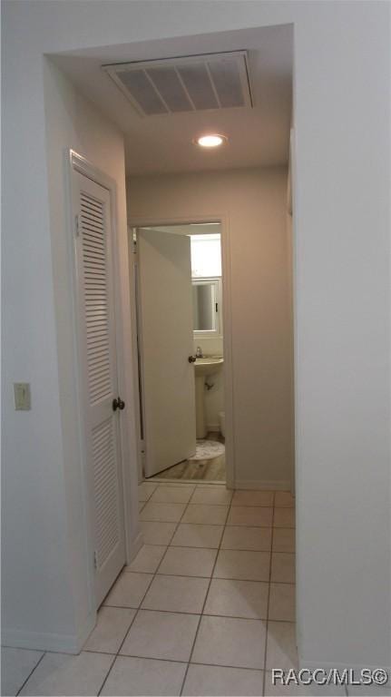 corridor with recessed lighting, visible vents, light tile patterned floors, and attic access