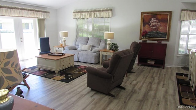living area with plenty of natural light, french doors, and light wood finished floors