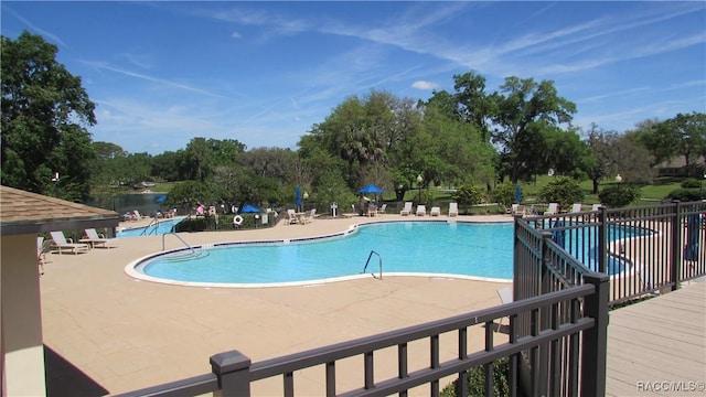 pool with a patio and fence