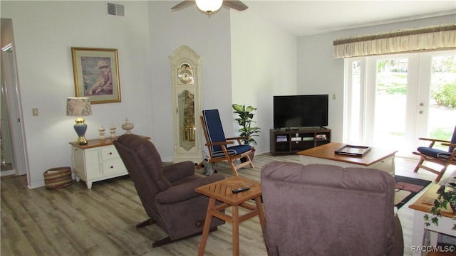living area featuring a ceiling fan, wood finished floors, and visible vents