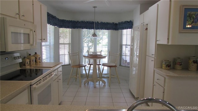 kitchen featuring light tile patterned floors, light countertops, white cabinets, and white appliances