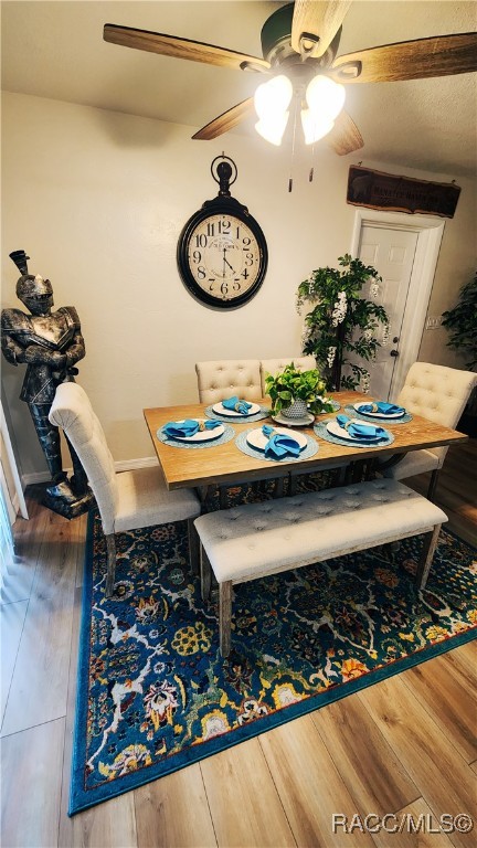 dining space featuring ceiling fan and hardwood / wood-style floors