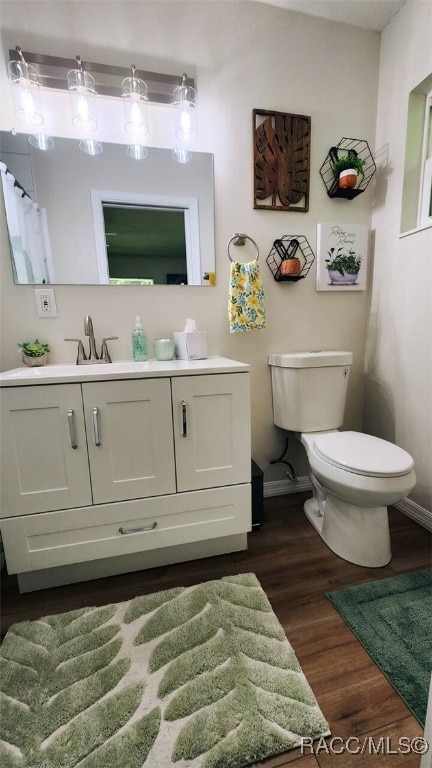 bathroom featuring hardwood / wood-style floors, vanity, and toilet