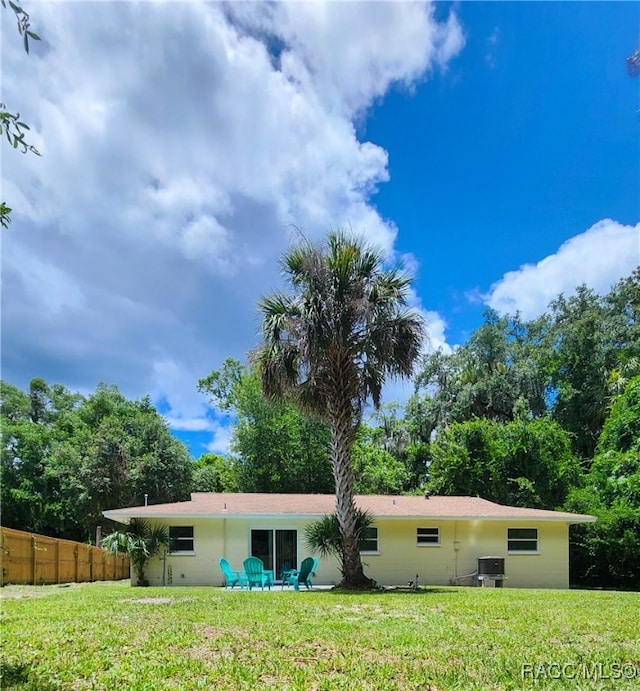 rear view of property with a yard and central AC