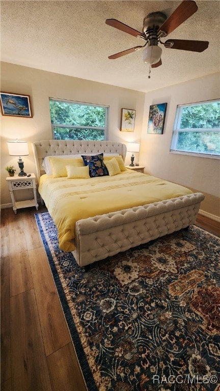 bedroom featuring ceiling fan, a textured ceiling, and hardwood / wood-style flooring